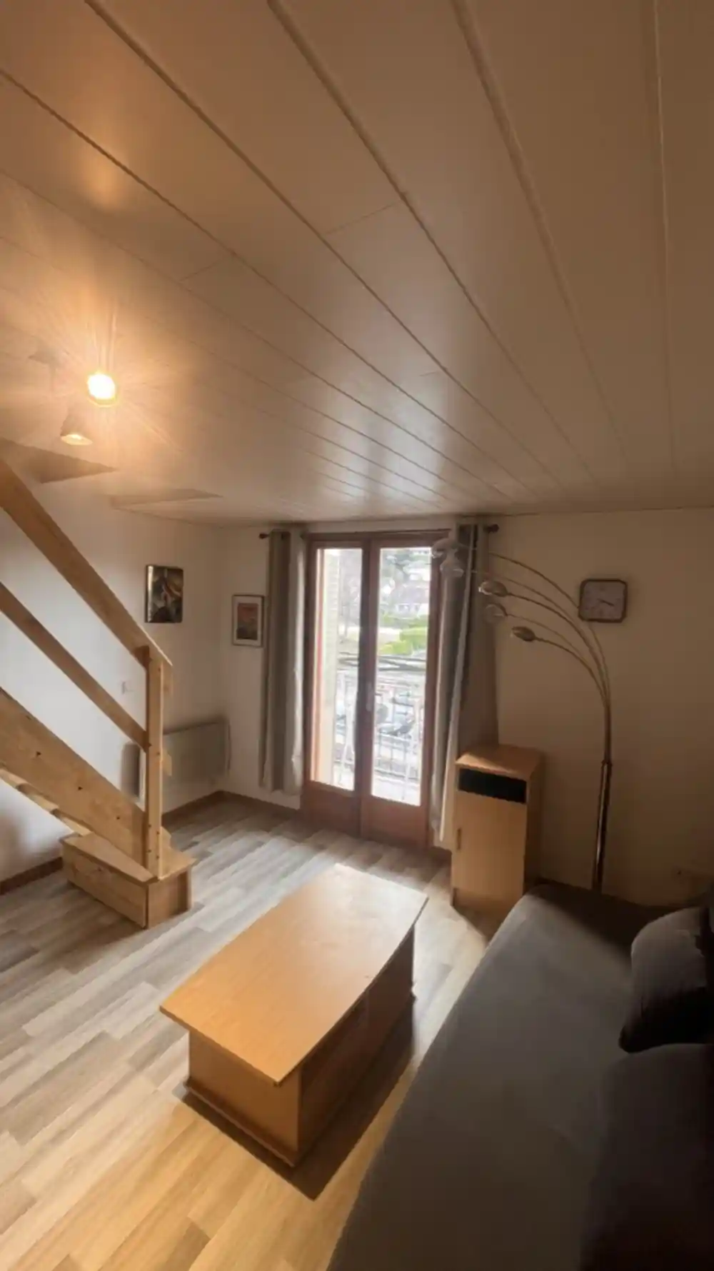 Salon avec escalier bois et porte-fenêtre